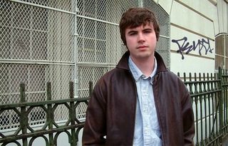 Cuellen stands in front of the elementary school where he used to teach.
